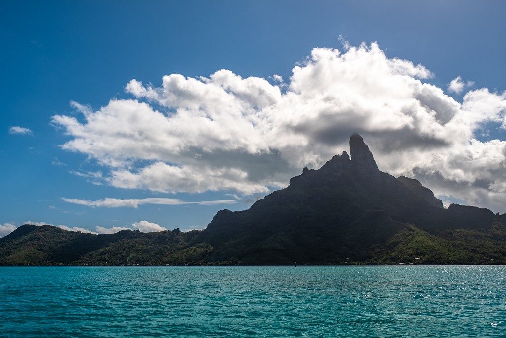 vista dell'isola centrale con cima vulcanica avvolta dalle nubi dal mare